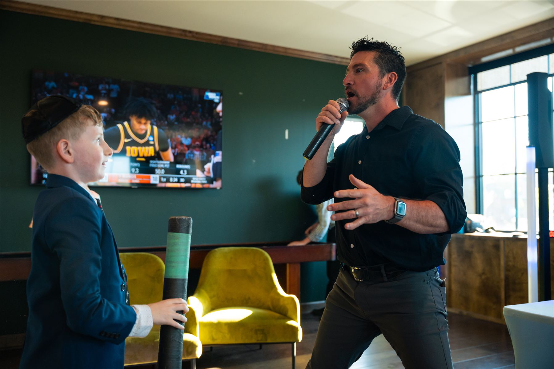 A DJ talking with a boy at a Bar Mitzvah while a game is played