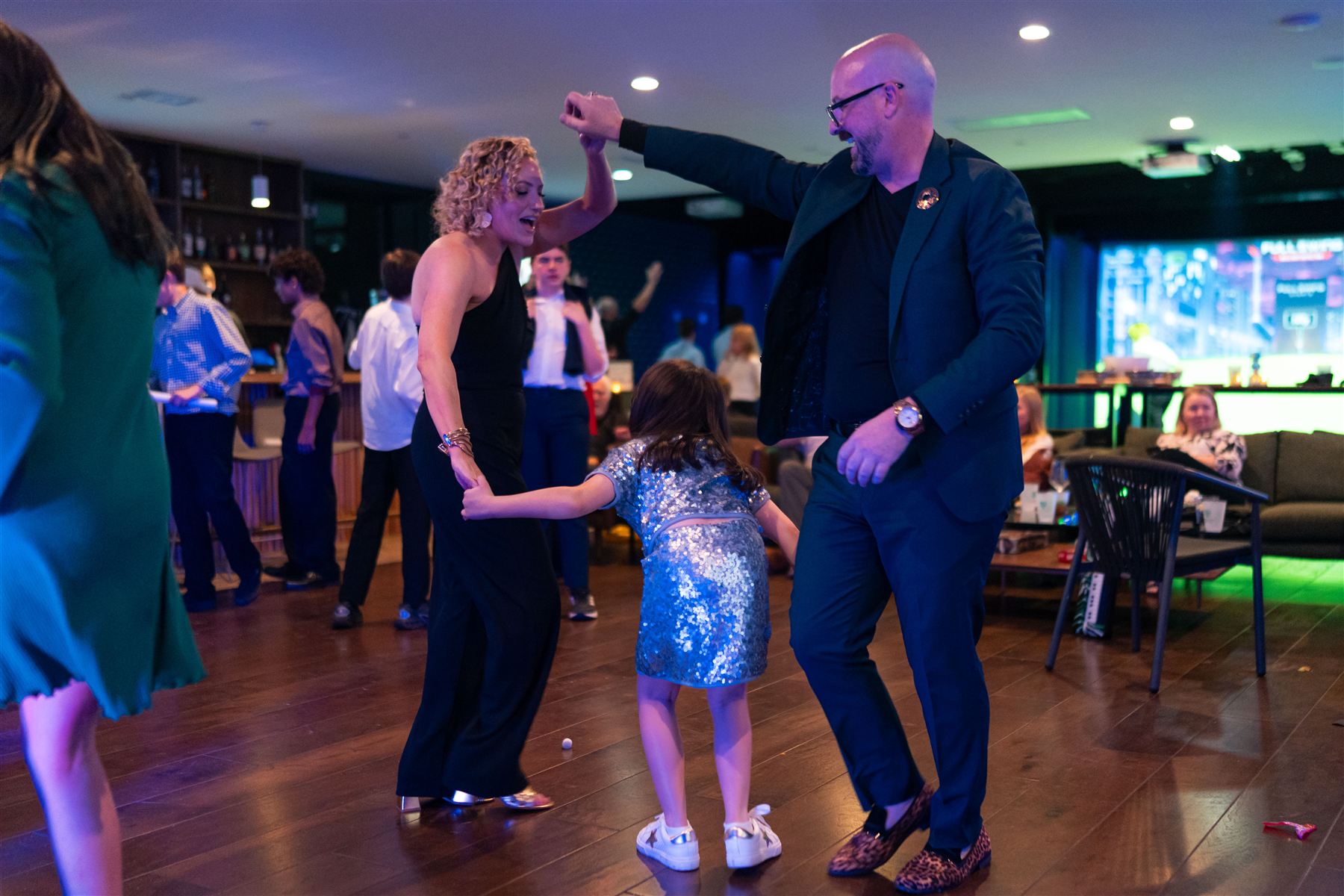 Adults and a young girl dancing together at a Bar Mitzvah party